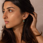Model wearing silver Jade Dome Drop Earrings featuring rounded green gemstones on dainty hoops.