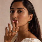 Model wearing gold Jade Dome Drop Earrings featuring rounded green gemstones on dainty hoops, styled with multiple gold rings.