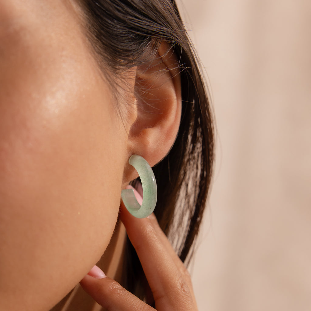 Model wearing Jade Hoop Earrings, featuring a chunky hoop design with a soft green natural jade gemstone.