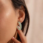 Model wearing Jade Hoop Earrings, featuring a chunky hoop design with a soft green natural jade gemstone.