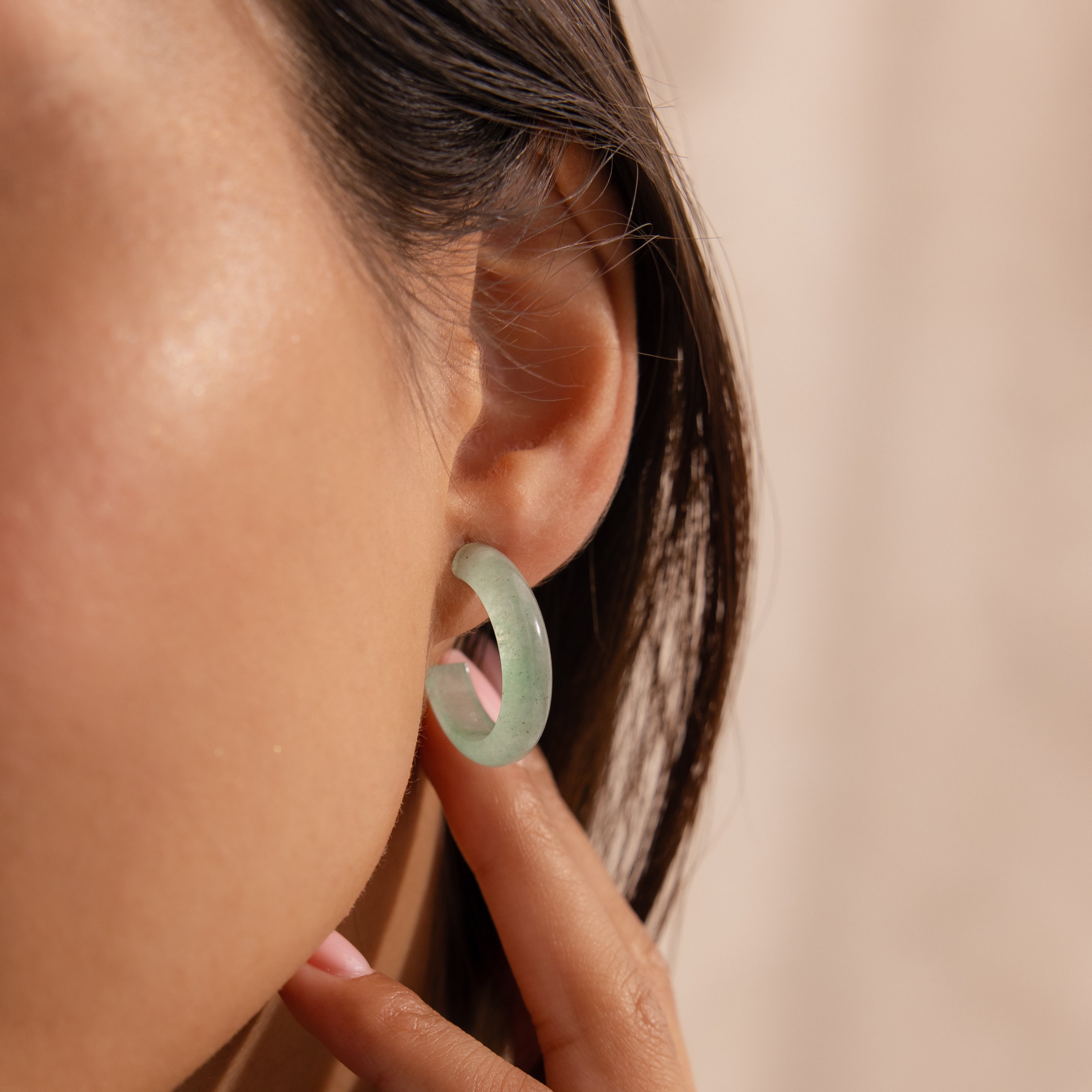 Model wearing Jade Hoop Earrings, featuring a chunky hoop design with a soft green natural jade gemstone.
