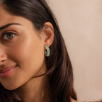 Model wearing Thick Jade Hoop Earrings, featuring a chunky hoop design with a soft green natural jade gemstone.