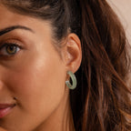 Model wearing Jade Hoop Earrings, featuring a chunky hoop design with a soft green natural jade gemstone.