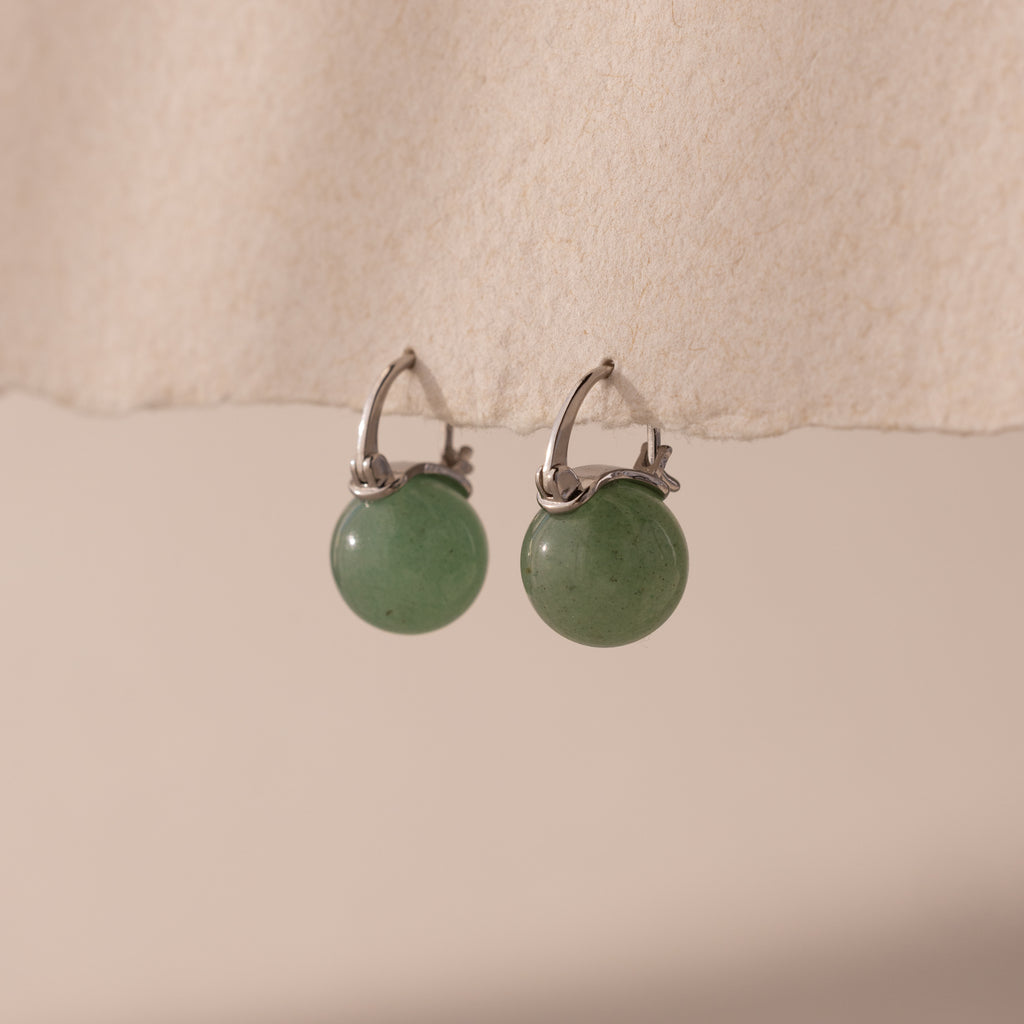 Silver Jade Dome Drop Earrings featuring rounded green gemstones on dainty hoops, displayed on a neutral paper.