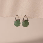 Silver Jade Dome Drop Earrings featuring rounded green gemstones on dainty hoops, displayed on a neutral paper.