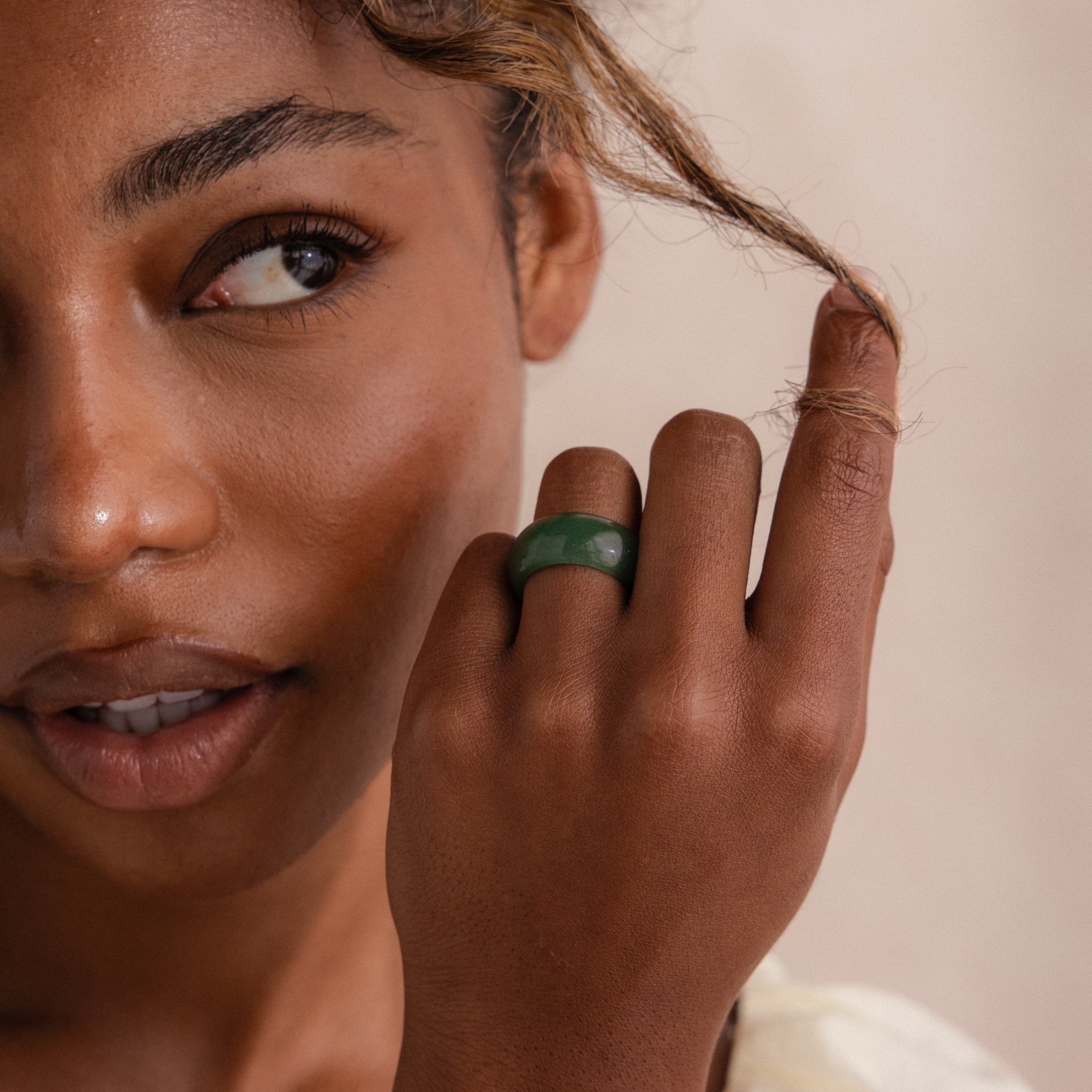 Model wearing a thick green jade gemstone statement ring with a smooth, glossy finish.