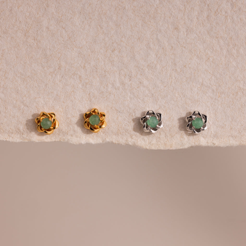 Set of four Mini Jade Flower Studs—two gold, two silver—with green stones, displayed on textured beige paper. These delicate earrings add an elegant touch to any outfit.