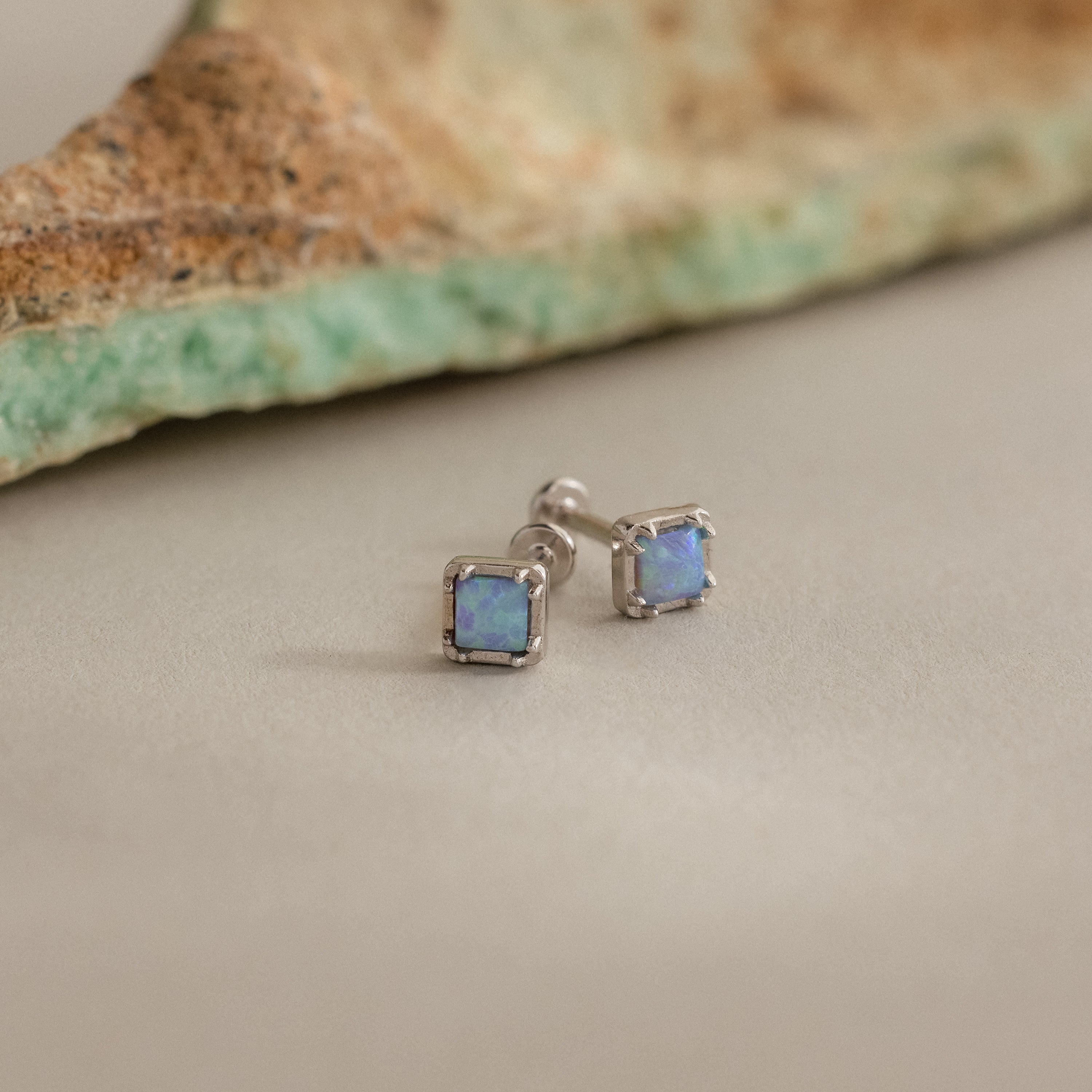Blue Opal Prism Studs feature iridescent blue stones set in silver, shown on a neutral background—ideal for fans of Iridescent Jewelry.