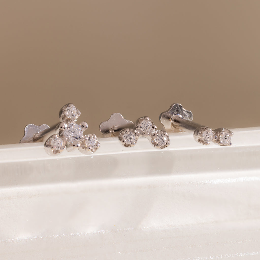 Three silver crystal cluster flat back stud earrings displayed on a white surface, showing graduated two, three, and four stone designs.