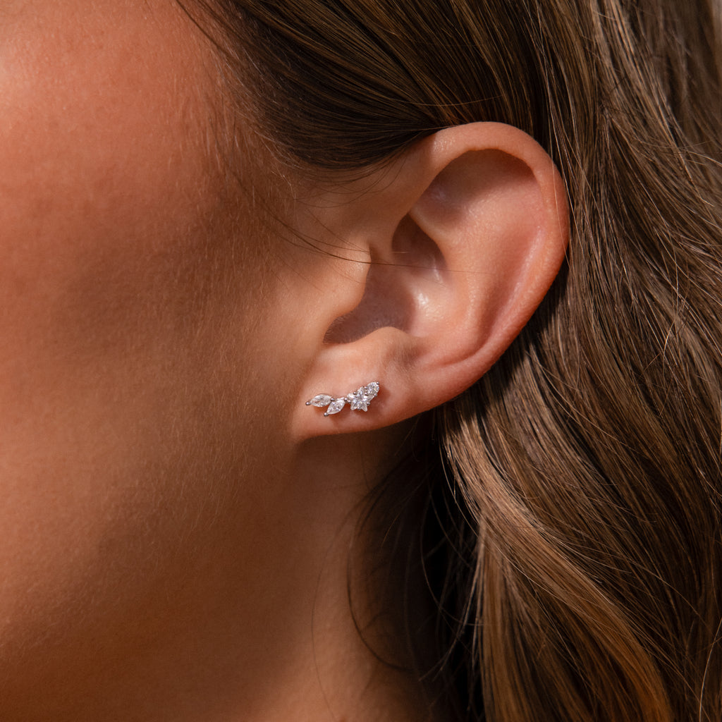 Close-up of a womans ear wearing Diamond Starfall Climbers in Silver, featuring delicate marquise cut gems arranged in a leaf-inspired design.