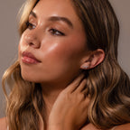 Woman with wavy hair touches her neck and looks to the side, wearing Diamond Starfall Climbers in Silver.
