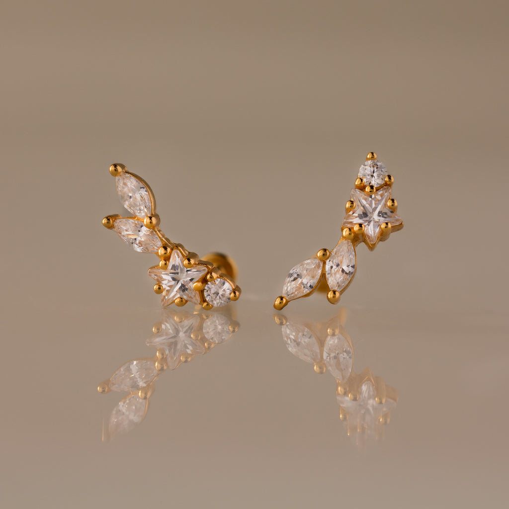 Diamond Starfall Climbers in 18K Gold, featuring marquise and round clear gemstones, elegantly displayed on a reflective beige surface.