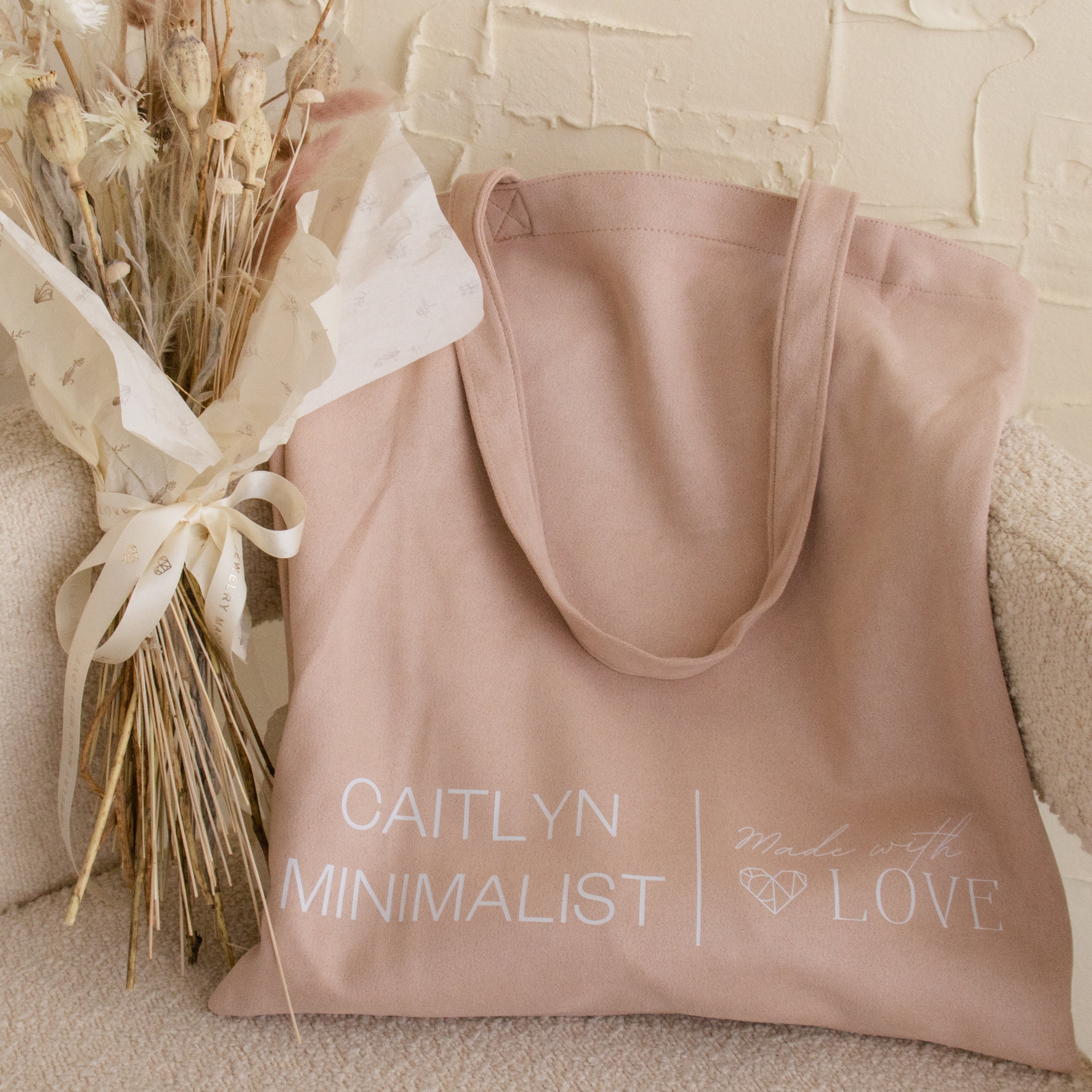 Free Gift of Choice blush pink tote bag with “Caitlyn Minimalist Made with Love” text, shown beside dried flowers—ideal for anyone who loves adorable totes or wants a stylish free gift.