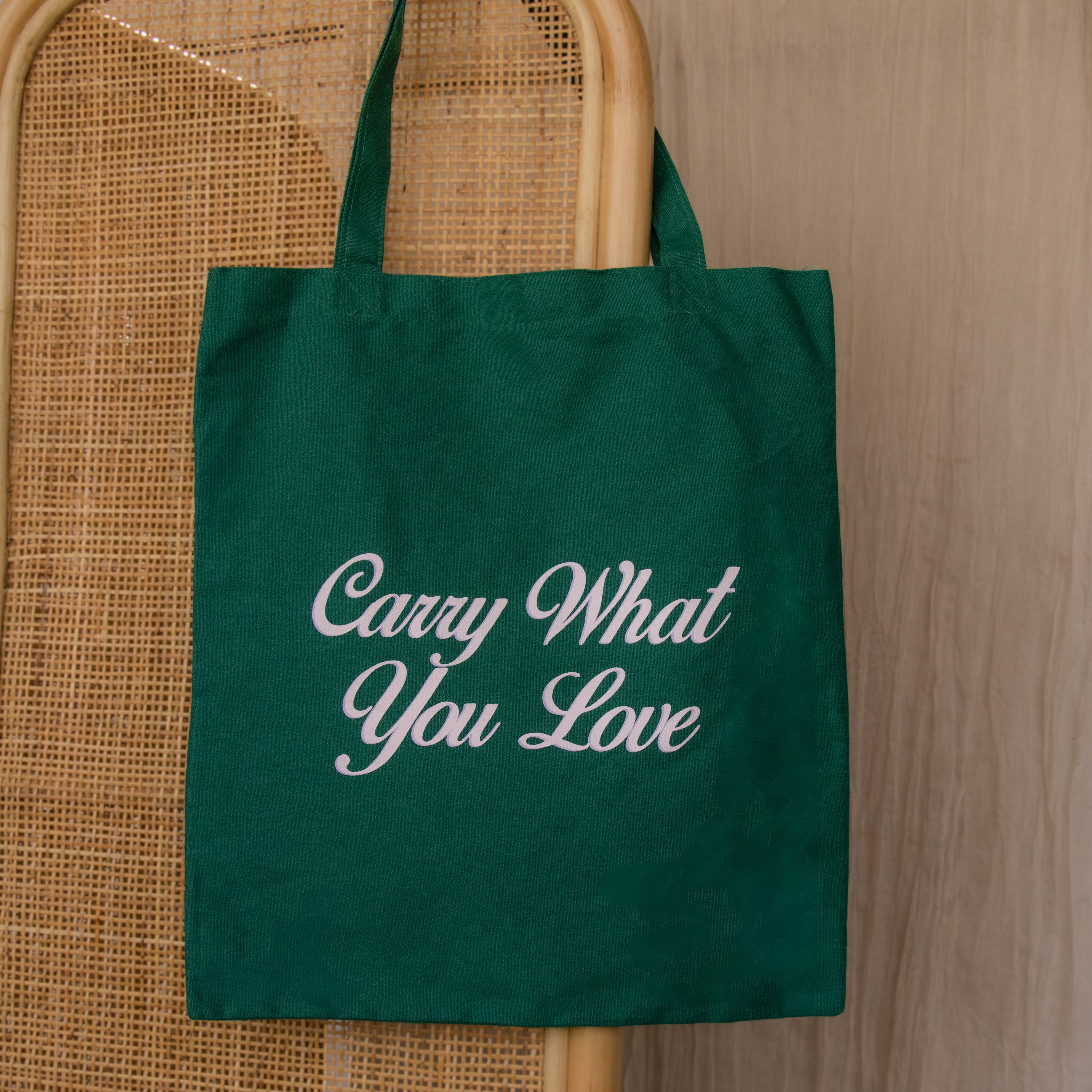 The Free Gift of Choice is a green tote bag featuring "Carry What You Love" in white script—ideal for tote bag enthusiasts or as a complimentary gift.