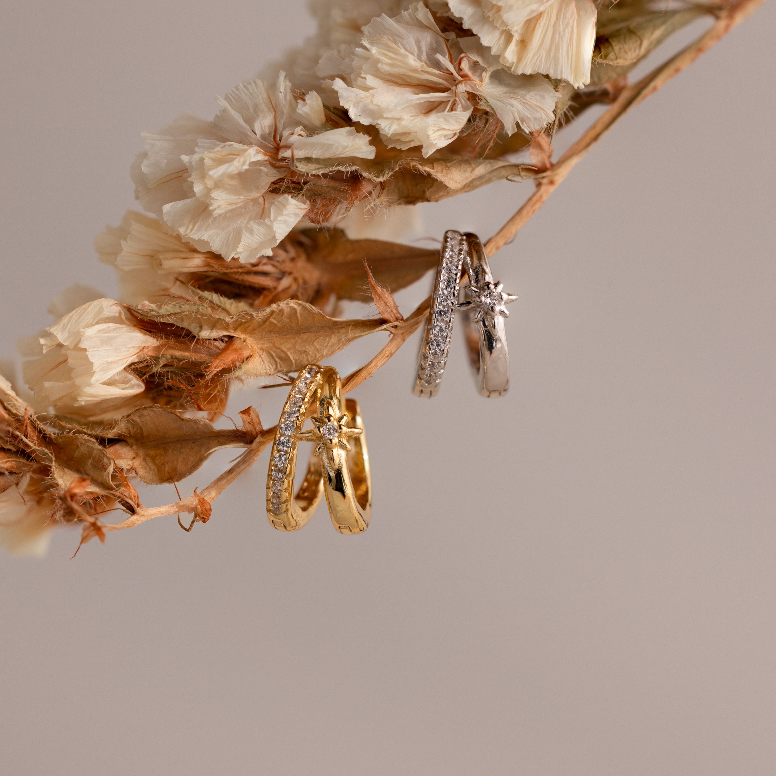 Gold and silver starburst duo hoops hanging from a branch