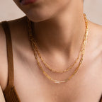 Close-up of a woman wearing the Paperclip Chain Necklace layered with another chain and styled with a brown top for a minimalist jewelry look.