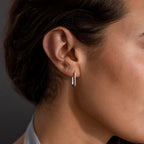 Close-up of a womans ear wearing Dainty Pave Link Earrings in Sterling Silver—minimalist small hoops adorned with sparkling cubic zirconia.