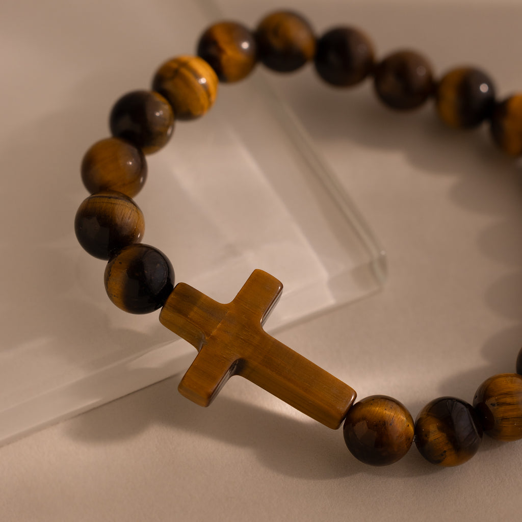 Close-up of the Tigers Eye Cross Bracelet featuring a smooth cross-shaped charm with round, polished beads.