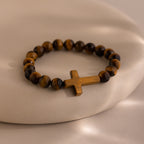 Tigers Eye Cross Bracelet featuring round polished tiger's eye beads and a horizontal tiger's eye cross charm, displayed on a neutral background.