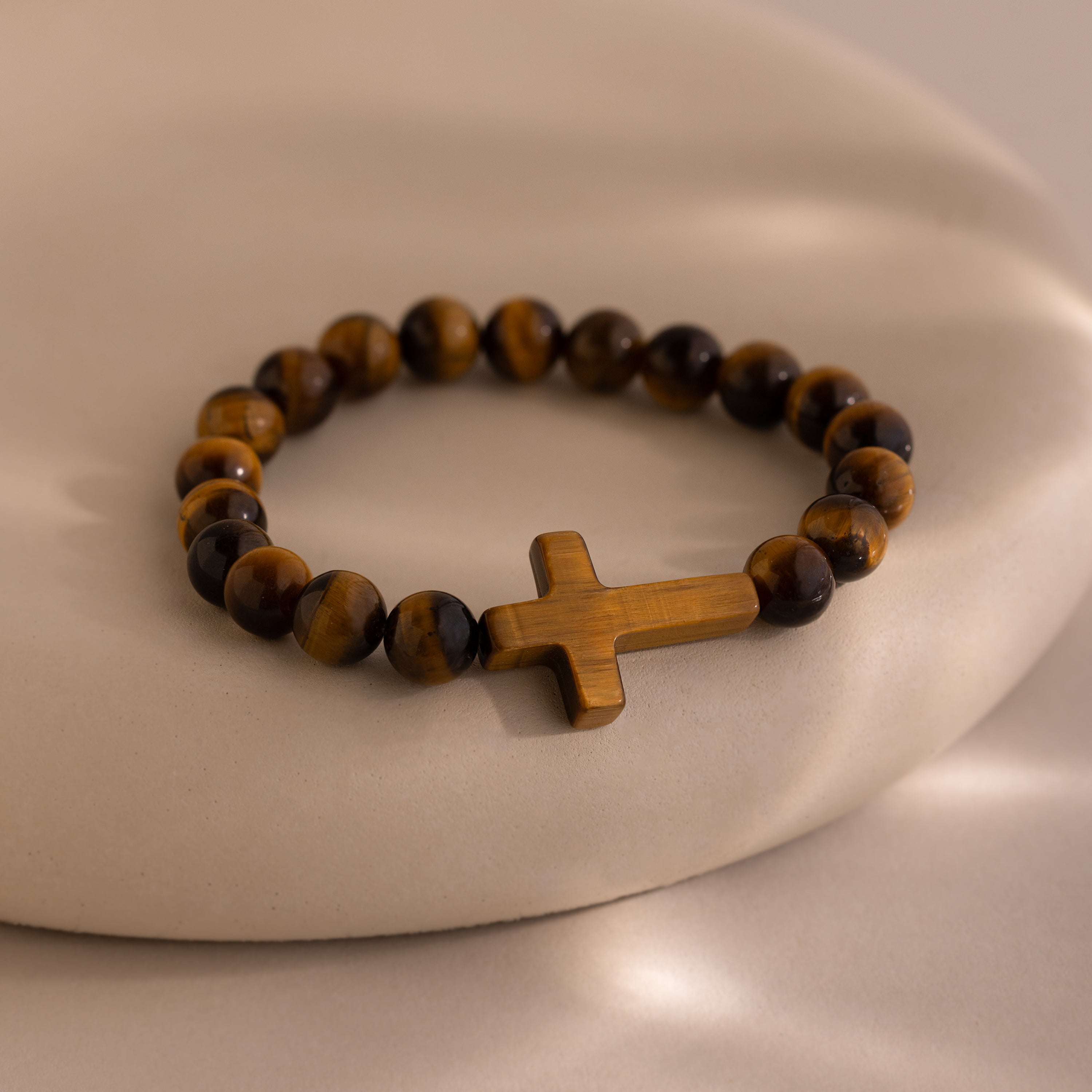 Tigers Eye Cross Bracelet featuring round polished tiger's eye beads and a horizontal tiger's eye cross charm, displayed on a neutral background.