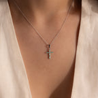 Model wearing a silver necklace with a jade cross pendant, featuring marquise-cut green stones and a CZ diamond center.