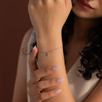 Silver chain bracelet with a delicate crystal cross charm, styled on the wrist for an elegant and minimal look, perfect for layering or everyday wear.