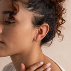 Model wearing a single 8mm silver small classic huggie hoop earring in her first lobe piercing.