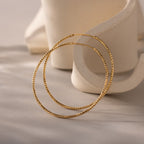 Gold hoop earrings featuring a distinctive faceted texture that adds brilliance and dimension.