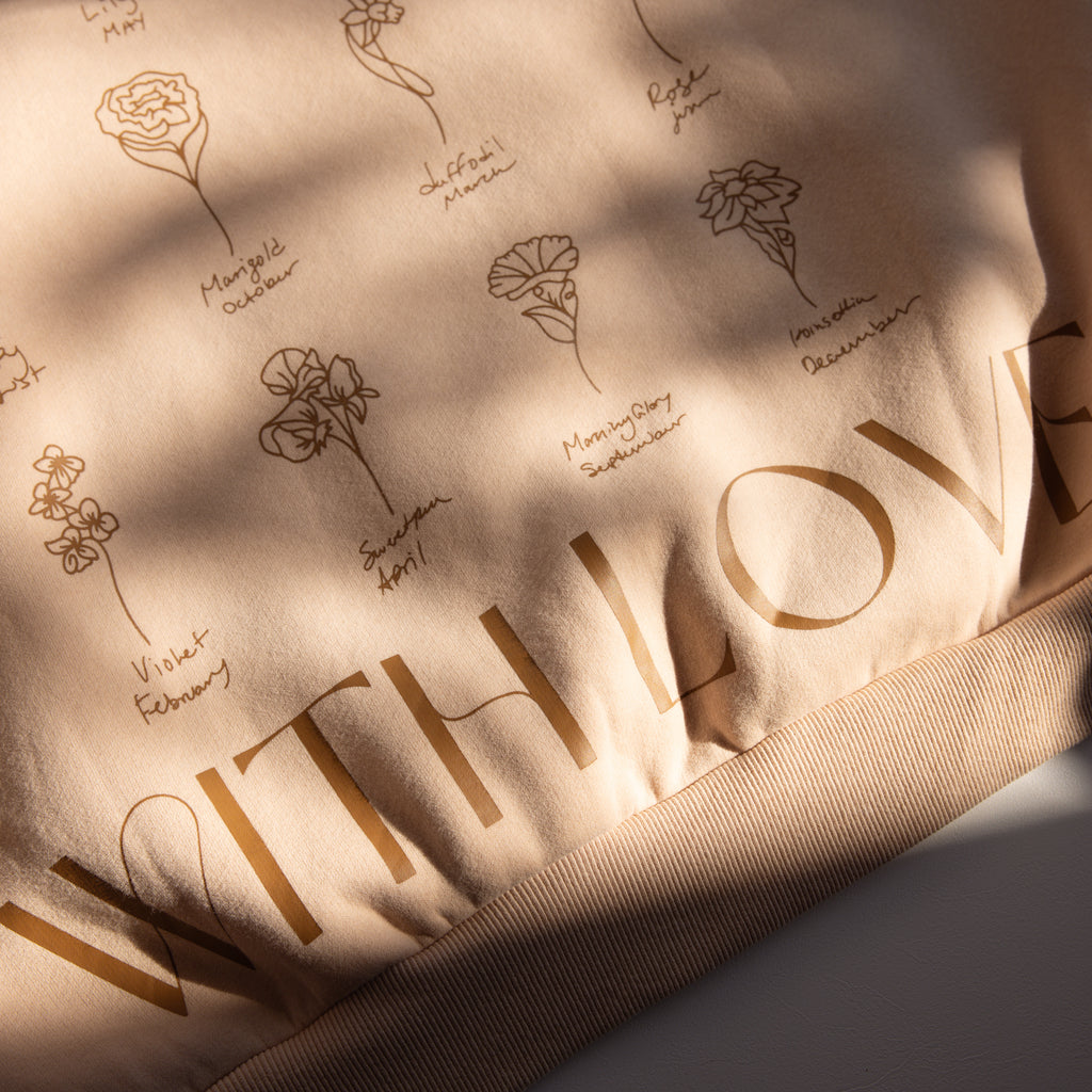 Beige fabric with floral sketches, handwritten names, and bold WITH LOVE in brown—perfect for a cozy Oversized CM Hoodie.