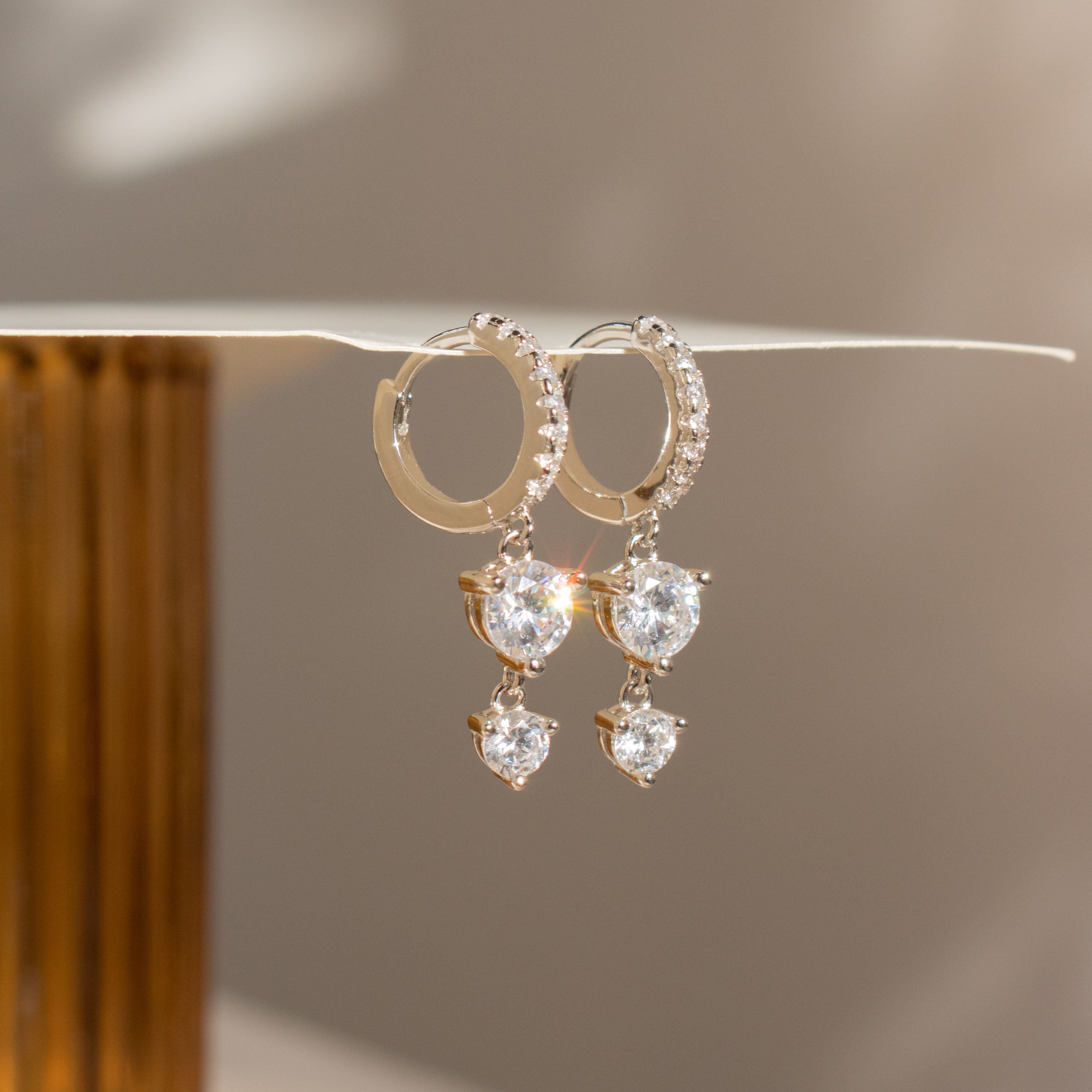 Caroline Pave Drop Huggies in Silver: sparkling hoops with teardrop and round crystals, designed for elegant shine—perfect for those who love timeless, embellished earrings.