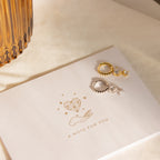 Caroline Pave Drop Huggies in Silver displayed on a card with heart and hand illustration, reading A NOTE FOR YOU.