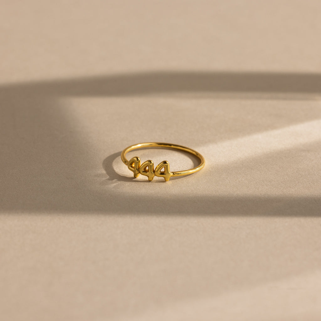 Close up of gold bubble numbers ring with 444