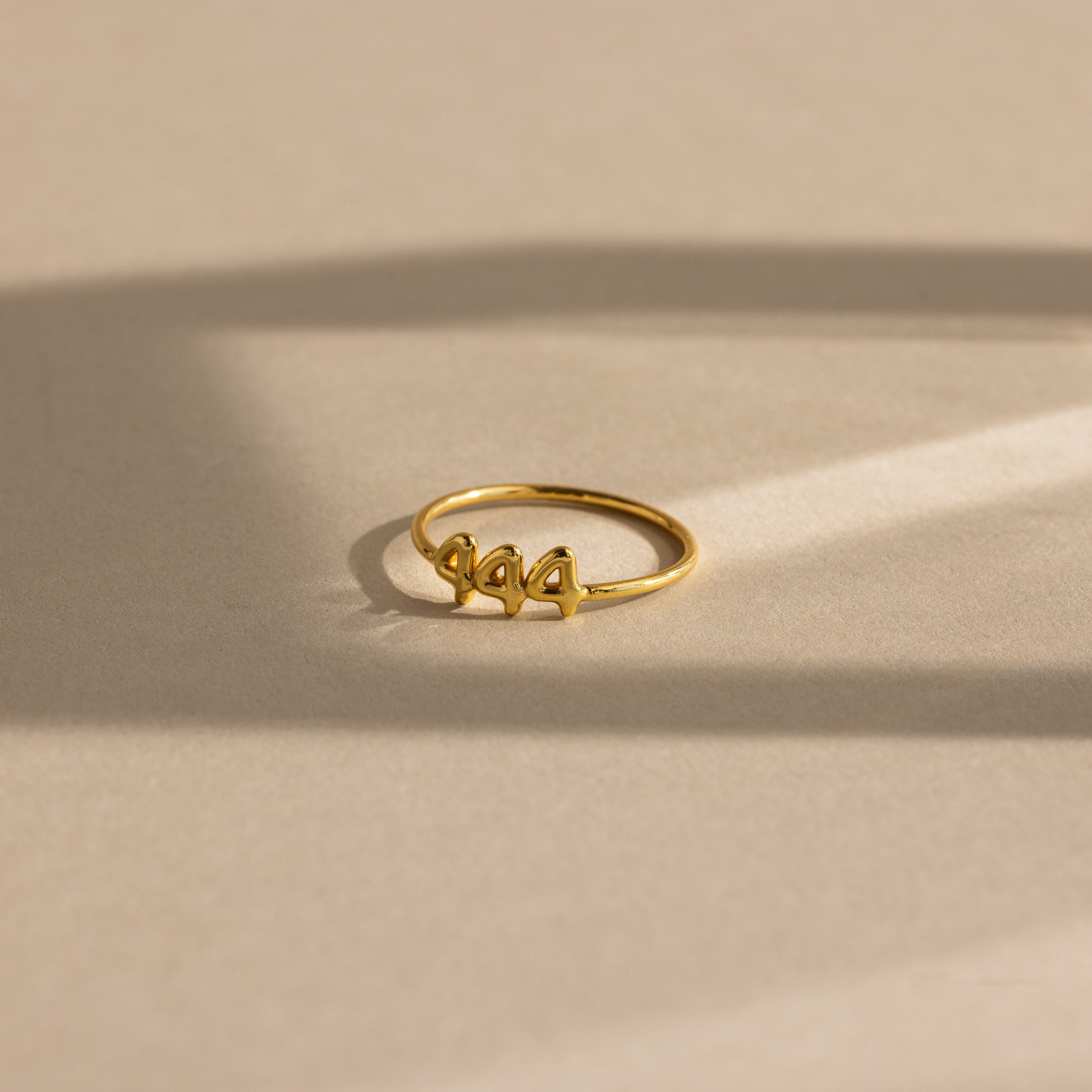 Close up of gold bubble numbers ring with 444