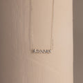 Dainty silver Brooke bubble name plate necklace displayed against a neutral surface.