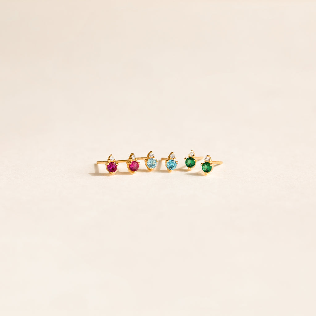 A gold ring with five pink, blue, and green gemstones set in a row on a light background, perfect to pair with Raindrop Topaz Studs for a coordinated look.