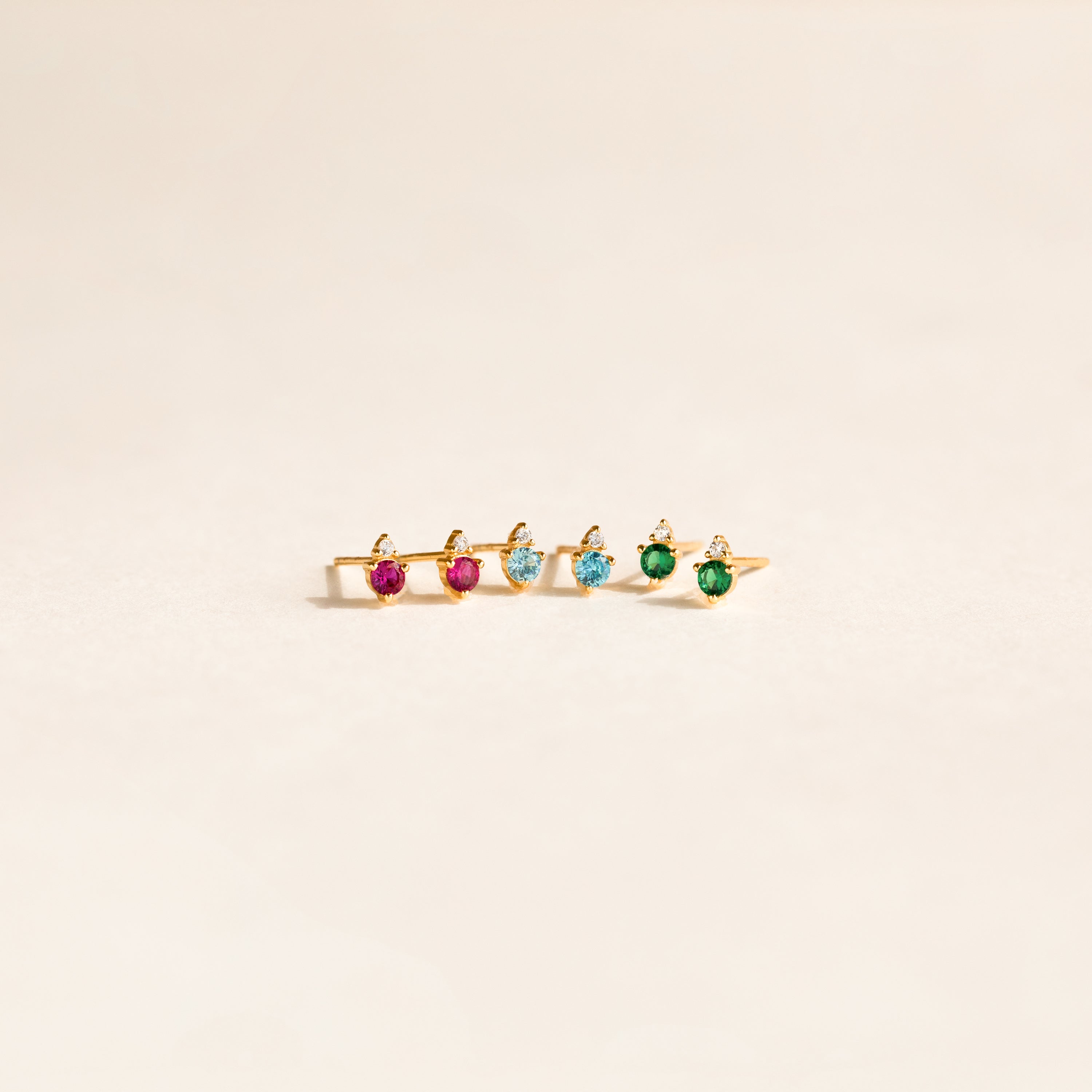A gold ring with five pink, blue, and green gemstones set in a row on a light background, perfect to pair with Raindrop Topaz Studs for a coordinated look.