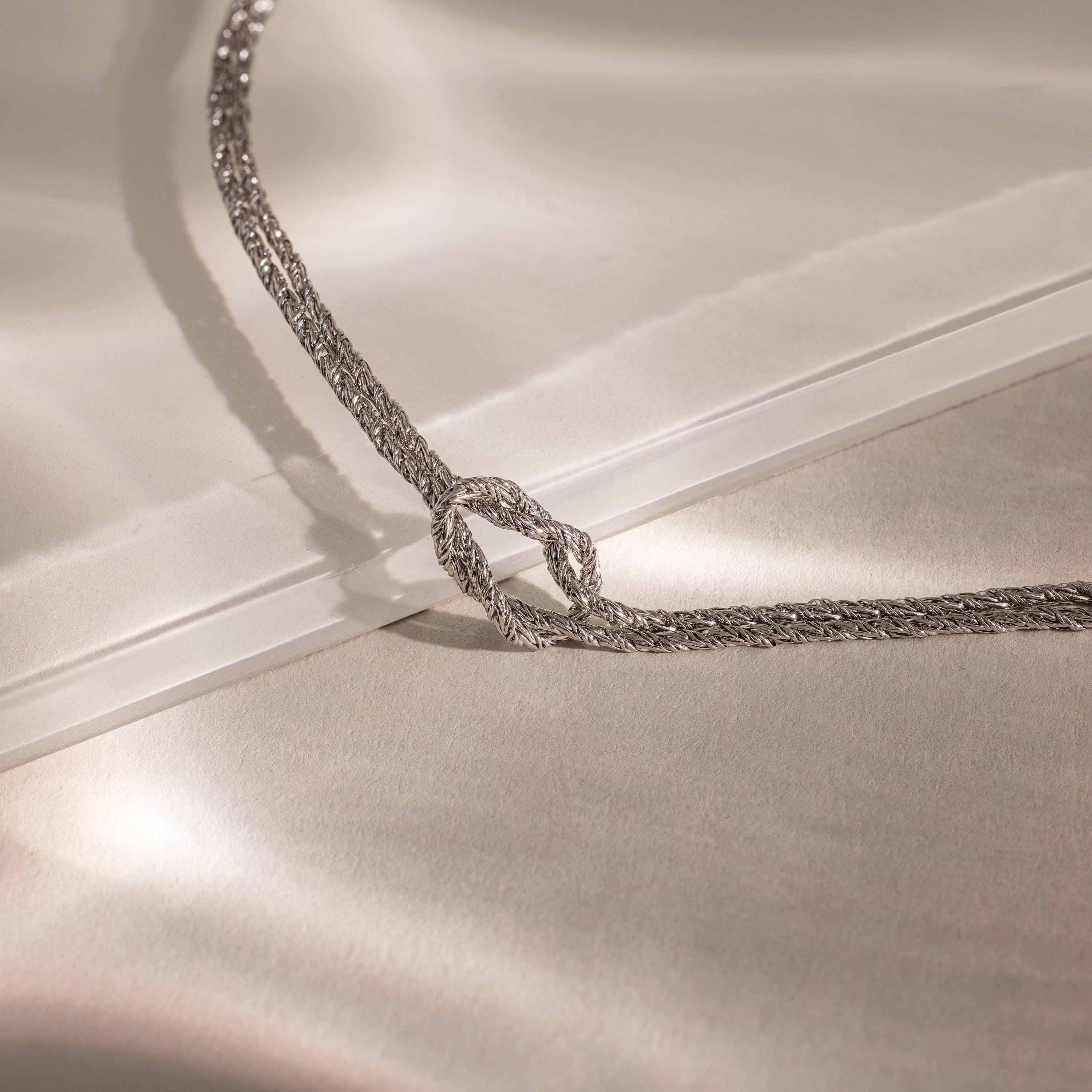 Close-up of the Rope Knot Chain Bracelet in silver with a center knot detail, displayed against a neutral background.