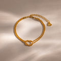 Flat-lay of the Rope Knot Chain Bracelet in gold with a center knot detail and duo chain design, displayed on a neutral background.