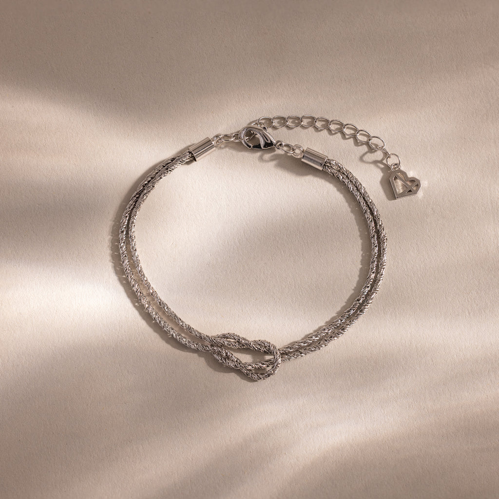 Rope Knot Chain Bracelet in silver with a center knot detail and duo chain design, displayed on a neutral background.