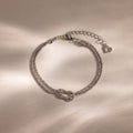 Rope Knot Chain Bracelet in silver with a center knot detail and duo chain design, displayed on a neutral background.