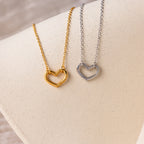 The Heart Carabiner Set in Sterling Silver features heart-shaped textured pendants displayed on a soft beige surface.
