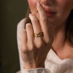A woman showcases the Zen Gemstone Curve Ring, featuring a sparkling gemstone, as she holds her hand close to her face.