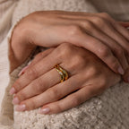 Close-up of hands with neatly manicured nails, wearing the Zen Gemstone Curve Ring—a minimalist gold band featuring a gemstone accent—on the ring finger.