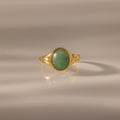 The Solace Jade Signet Ring features an oval-cut jade stone set at the center, showcased on a neutral background—a modern heirloom with timeless elegance.