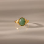 The Solace Jade Signet Ring features an oval-cut jade stone set at the center, showcased on a neutral background—a modern heirloom with timeless elegance.