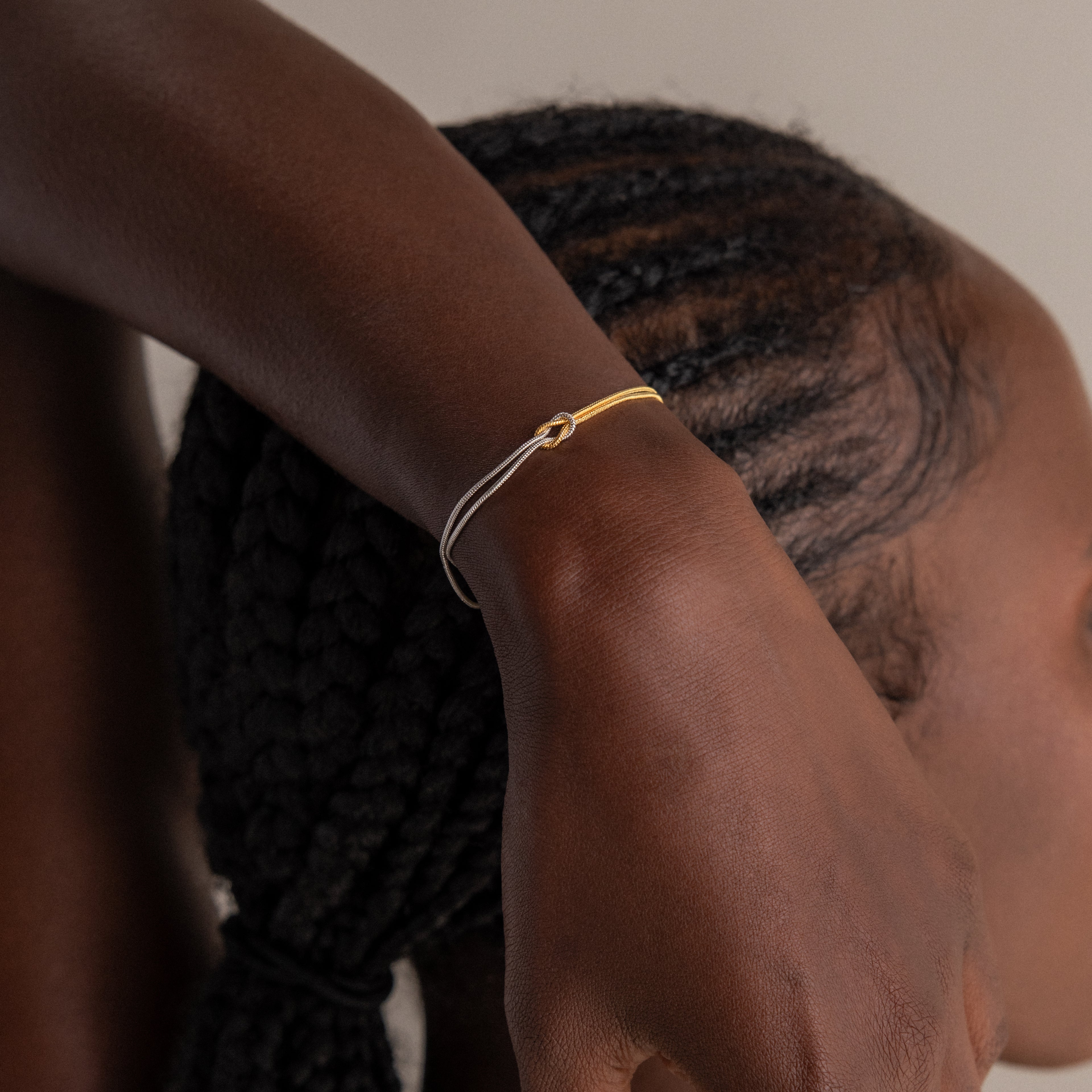 A woman wearing a Mixed Metal Knot Bracelet.