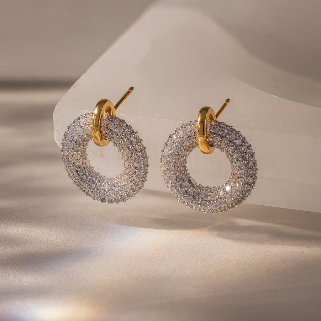 Mixed Metal Pave Circle Studs, crafted with gold and diamond pavé, are featured against a white translucent stone background.