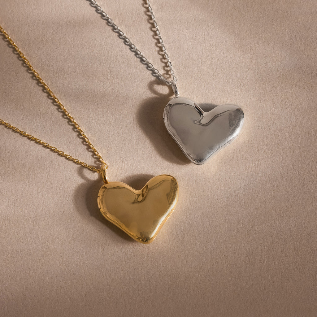 The Organic Heart Locket Necklace, available in gold and silver on matching chains, is displayed on a neutral background—an ideal keepsake for treasured memories.