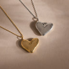 The Organic Heart Locket Necklace, available in gold and silver on matching chains, is displayed on a neutral background—an ideal keepsake for treasured memories.