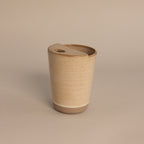 The Everyday Ceramic Mug comes with a matching lid and features a subtle speckled beige glaze, shown against a light neutral background.